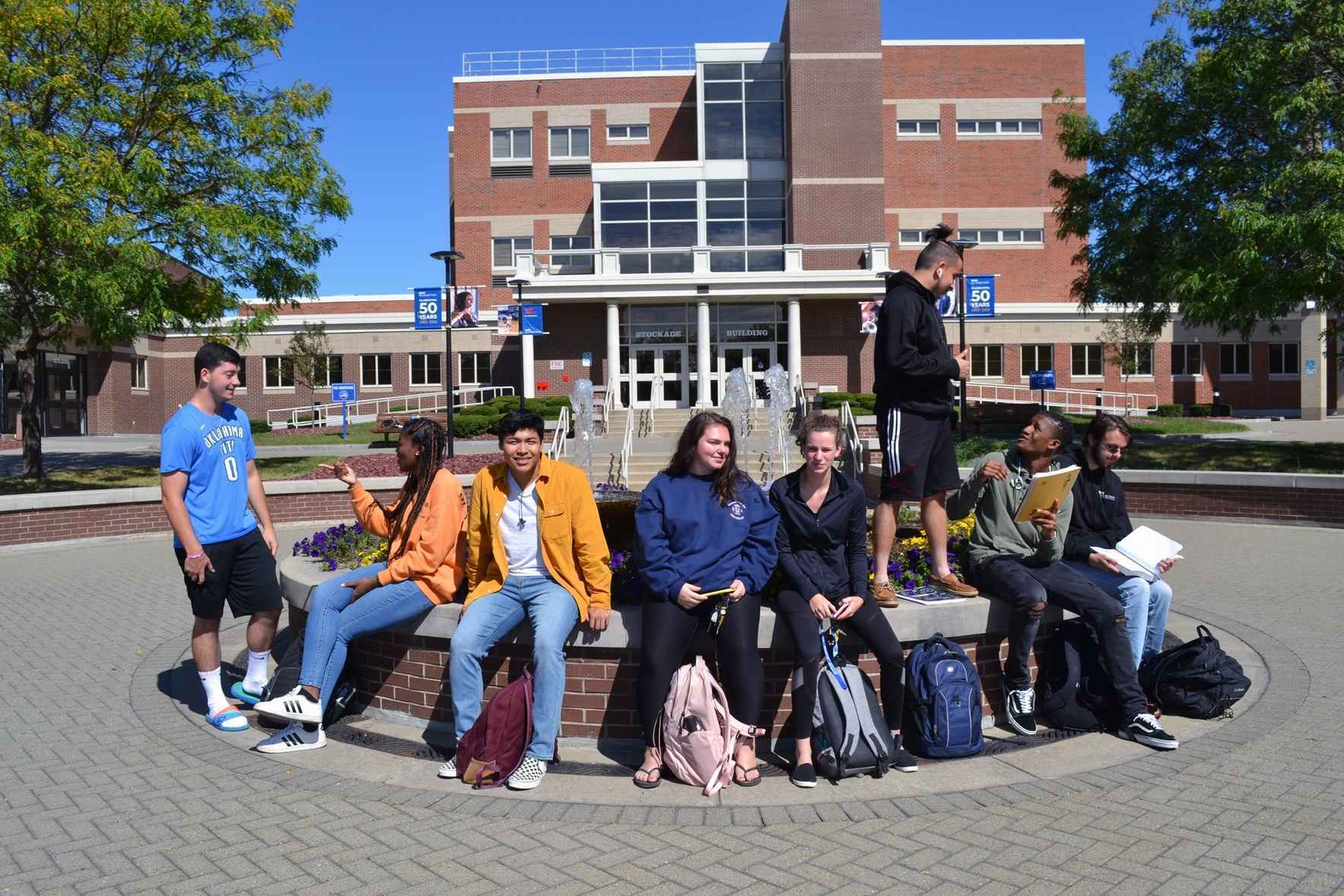 Students sitting on the fountain in the quad at SUNY Schenectady