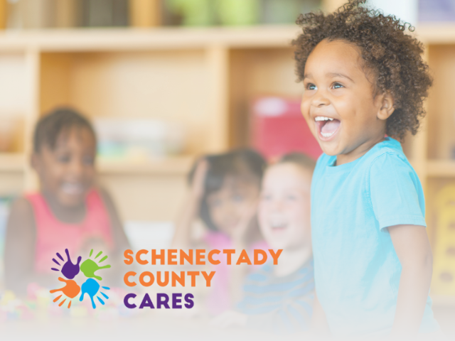 photo of male preschool teacher at a table with pre-school aged child with the text Schenectady County Cares