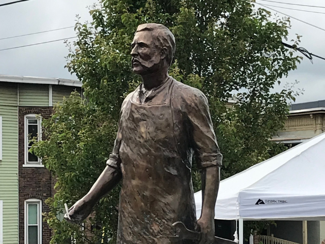 Photo of a bronze statue depicting George Westinghouse Jr. wearing an industrial apron hold a wrench. The statue is located in the City of Schenectady.  