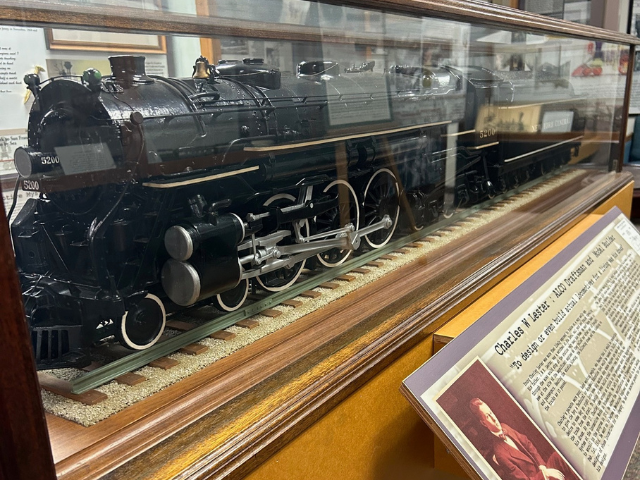 Photo of a bkack model Alco Train in a glass case