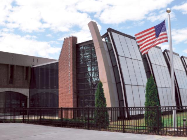 Photo of the outside of the Hon. Karen B. Johnson (Central) Library with an American Flag flying