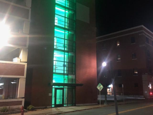 Photo of the municipal parking garage lit up in green