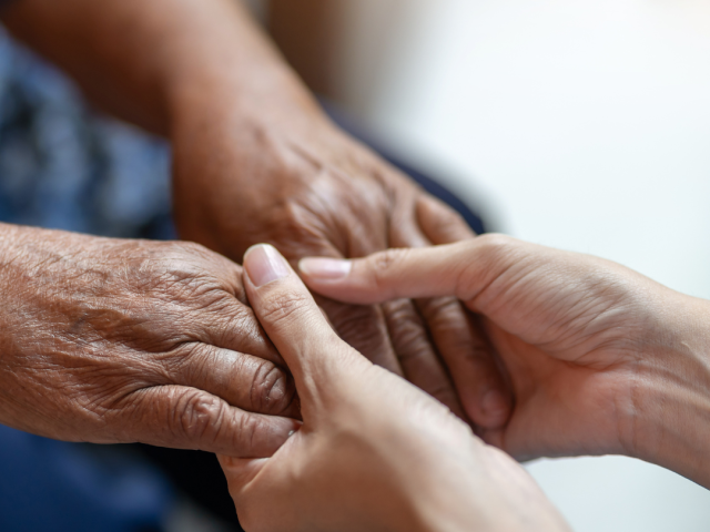 Photo of a younger pair of hands holding an older pair of hands