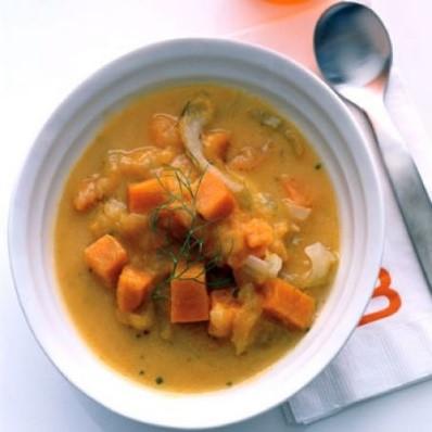 a photo of a white bowl filled with chunks of orange sweet potato in a Sweet Potato Soup.  